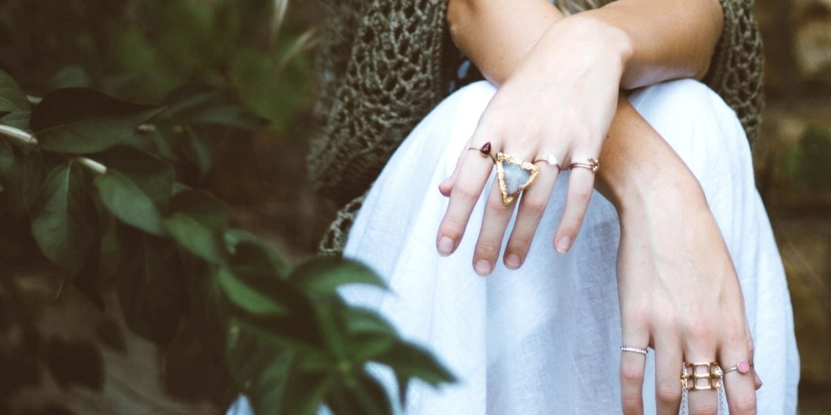 A woman wearing multiple rings, representing a large inventory. Moving to on-demand production is one of the best ways to improve efficiency in your jewelry business.